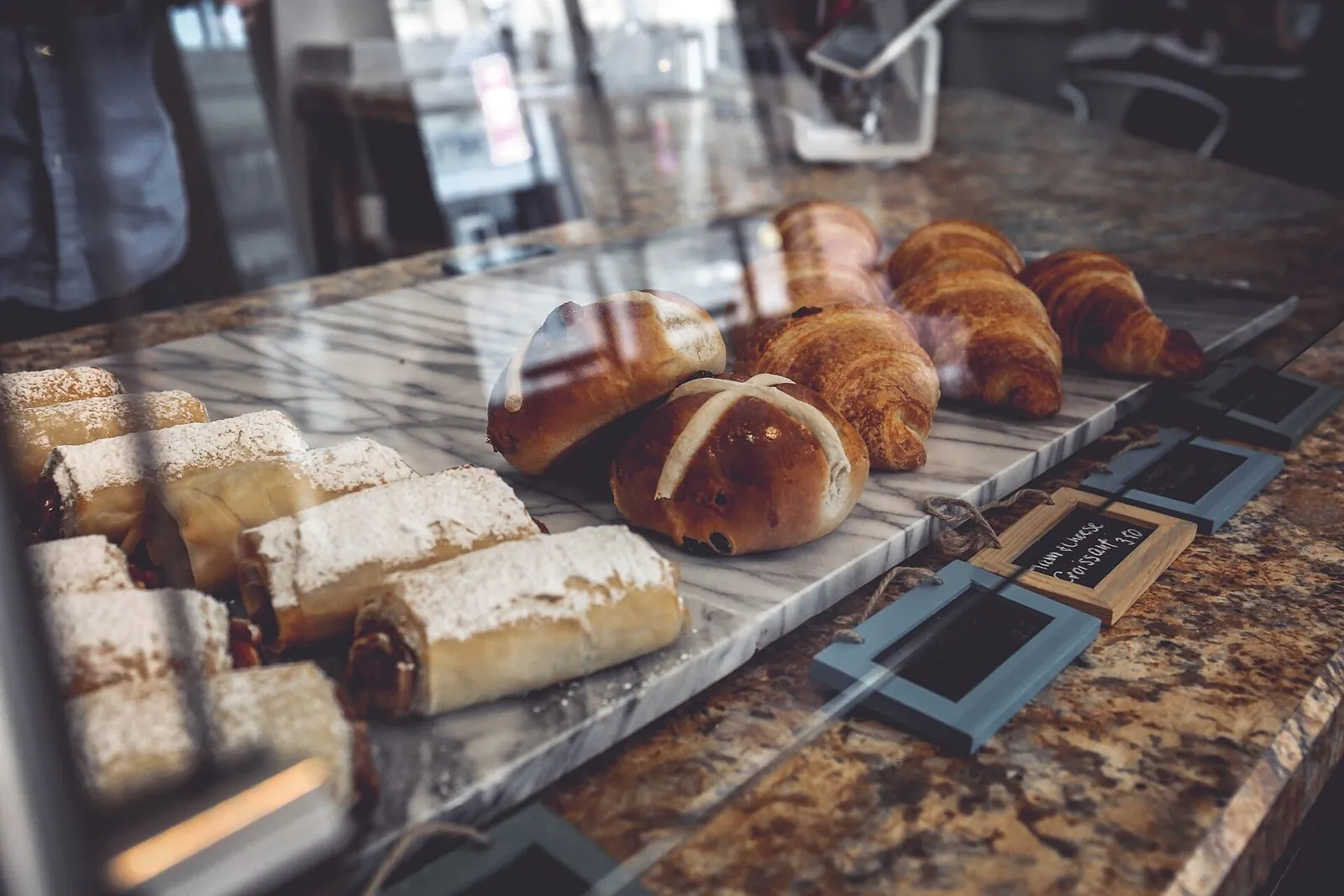 Croissants and pastries on a marble counter in an artisan bakery